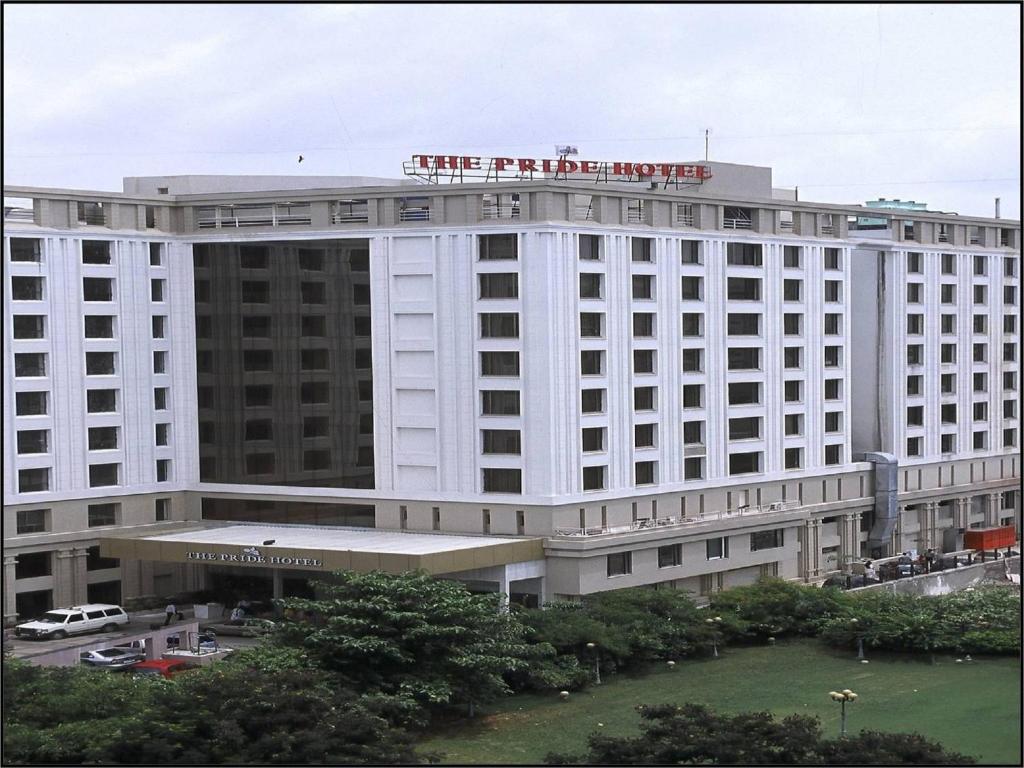 a large white hotel with a sign on top of it at Pride Plaza Hotel, Ahmedabad in Ahmedabad