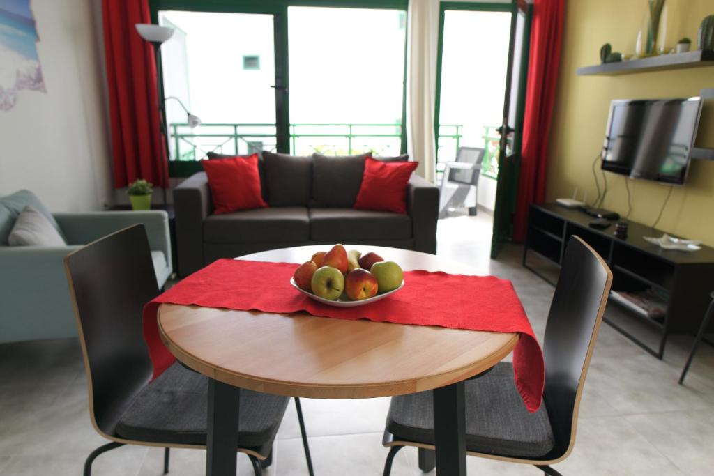 una sala de estar con una mesa con un bol de fruta. en Apartment Portonovo Casa Martin - Piscina - Wifi - Old Town, en Puerto del Carmen