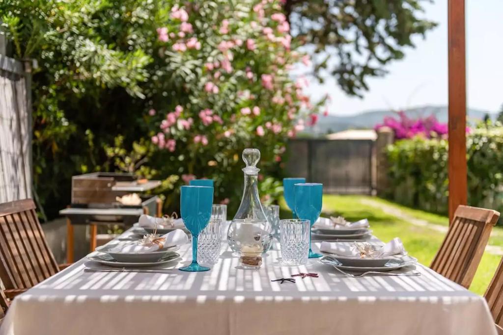 un tavolo con una tovaglia bianca e bicchieri blu di Capitana Rooms a Costa degli Angeli