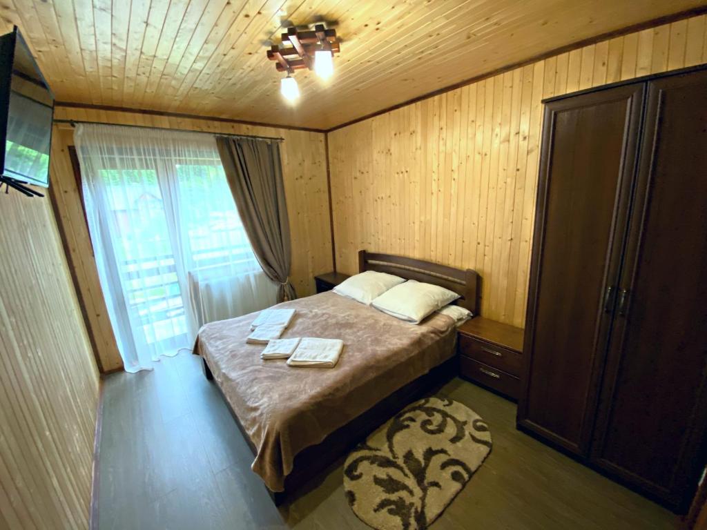 a small bedroom with a bed and a window at Під Магурою in Vorokhta