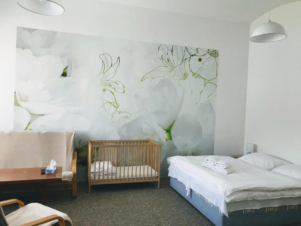 a bedroom with a bed and a crib in it at Apartman na namesti in Opočno