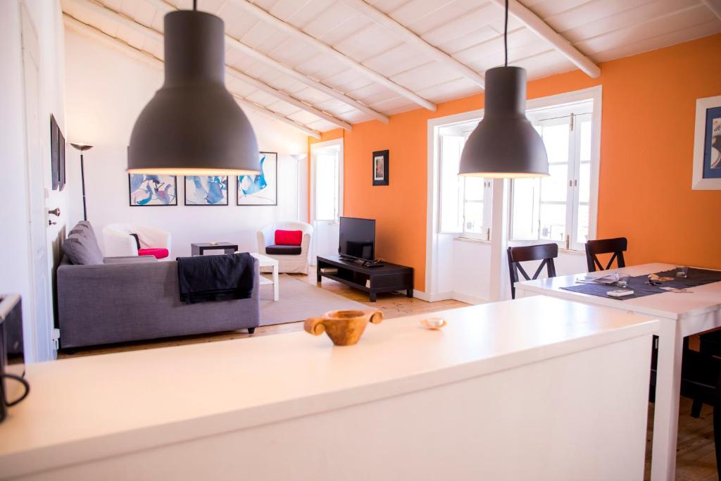 ein Wohnzimmer mit zwei Hängelampen und einem Sofa in der Unterkunft Apartamento Joaquim Tello in Lagos