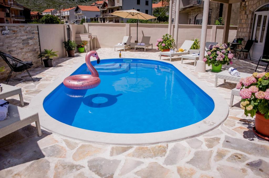una piscina con un flamenco rosa en el medio en Villa Branka apartments near Dubrovnik with Pool, en Ivanica