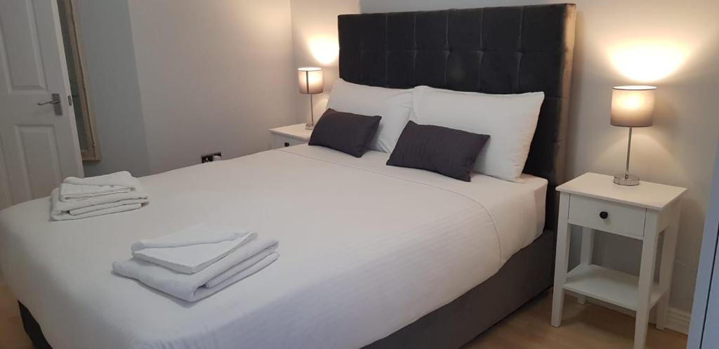 a bedroom with a large white bed with towels on it at Apartment in the heart of wexford town in Wexford