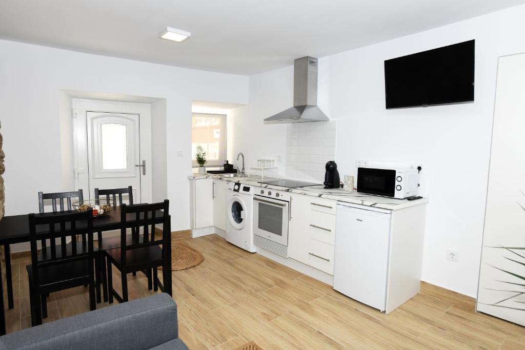 a white kitchen with a table and a dining room at Dúplex Costa de Fisterra I in Finisterre