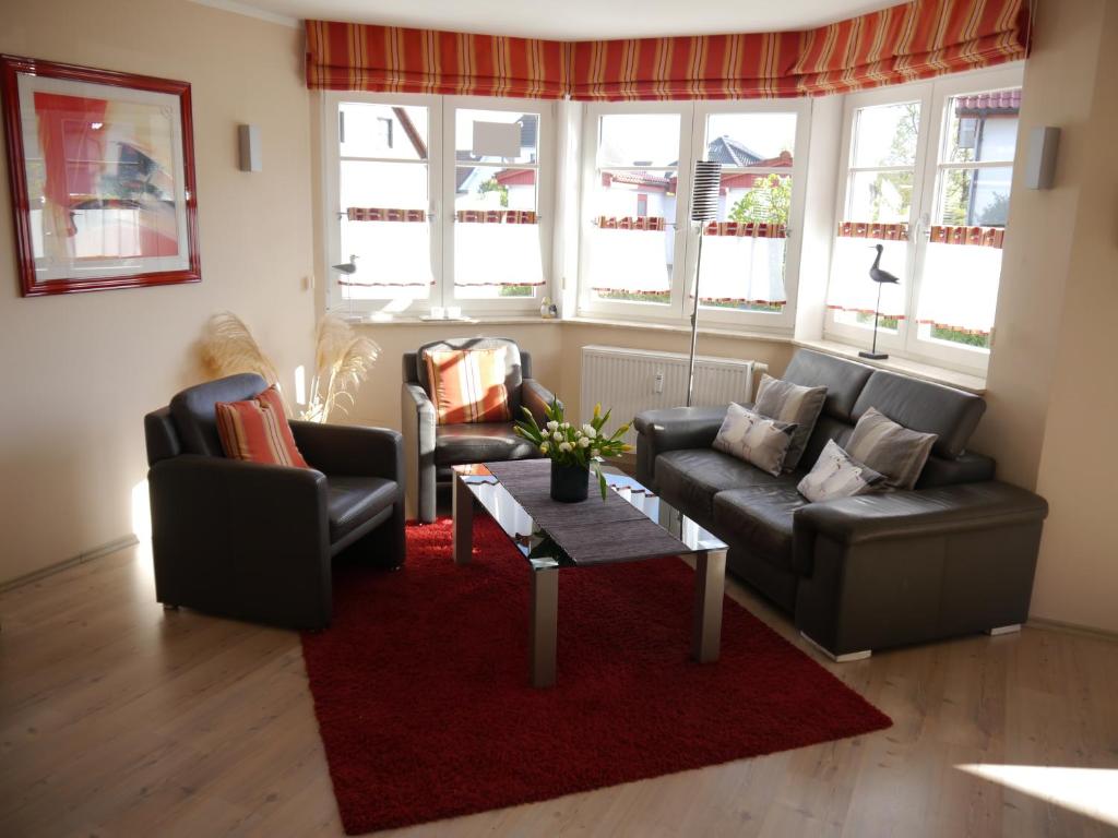 a living room with two couches and a red rug at Wolkenlos in Zingst