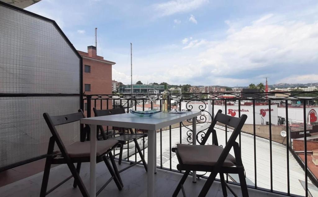 een tafel en stoelen op een balkon met uitzicht bij White Apartment in Lloret de Mar