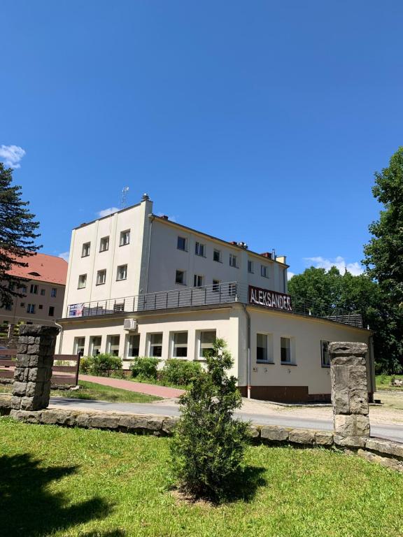 a white building with a sign on it at Aleksander in Długopole-Zdrój