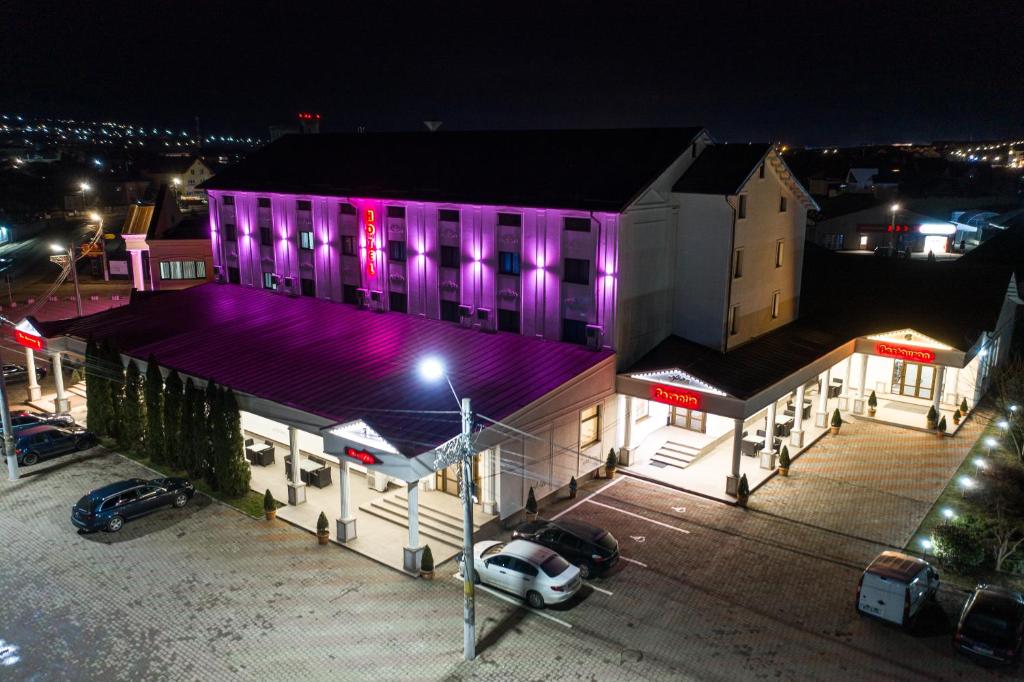 um edifício com luzes roxas à noite em Hotel Polaris em Suceava