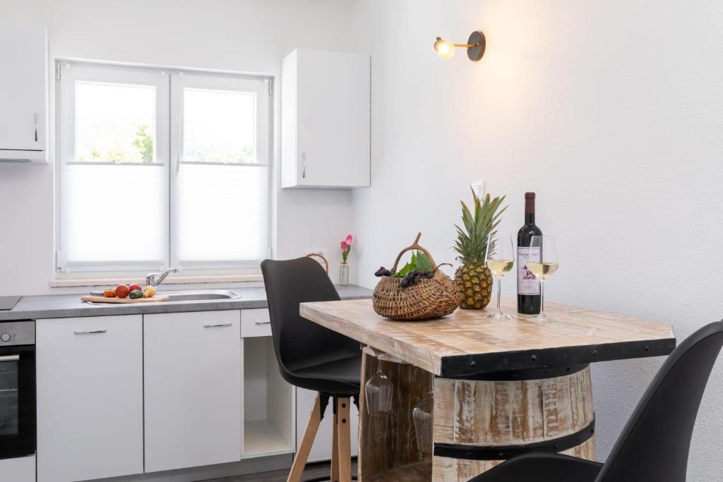 een keuken met een tafel en een fles wijn bij MALOA One bedroom apartment in Smokvica