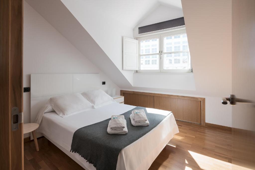 Un dormitorio con una cama con dos zapatos. en Atico en Santa Catalina, en A Coruña
