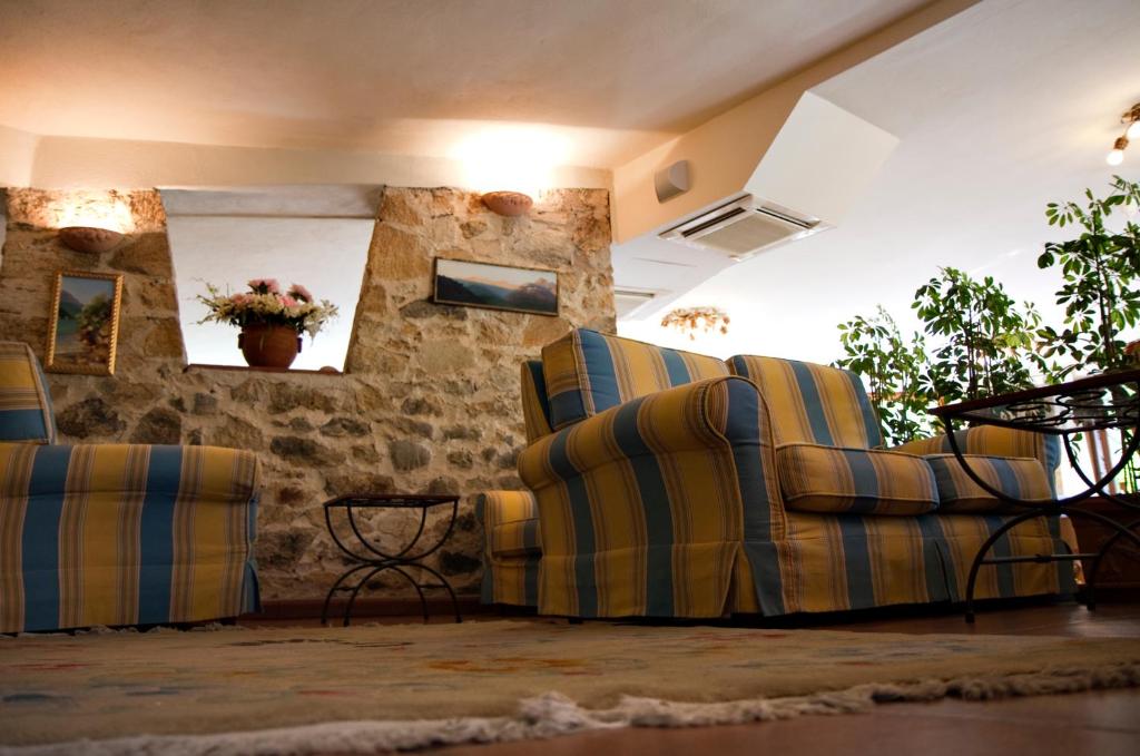 a living room with three chairs and a table at Hotel Danila in Portoferraio