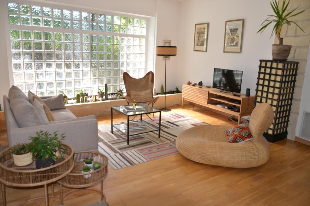 uma sala de estar com um sofá e uma televisão em KAROUBA.31 em Avignon
