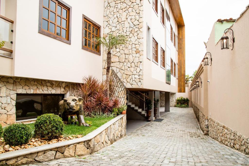 a statue of a dog sitting in the grass next to a building at ESPAÇO 250 - Apto mobiliado, 3 quartos, sendo uma suíte, banheiro social, cozinha completa, sala de estar, ar condicionado, tv e internet in Tiradentes