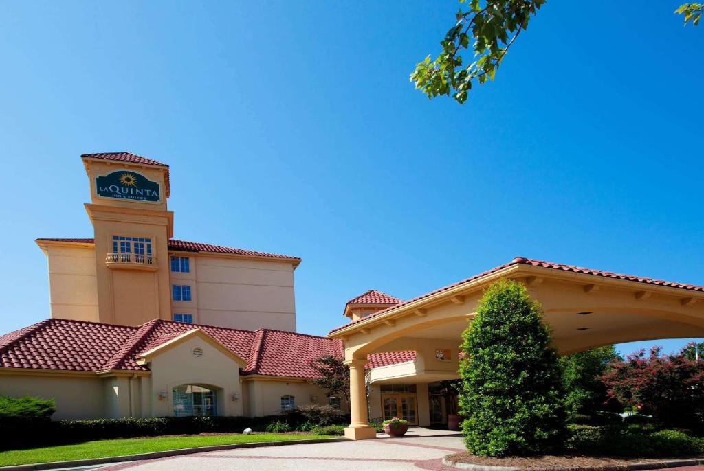 a large building with a sign on top of it at La Quinta by Wyndham Greensboro NC in Greensboro
