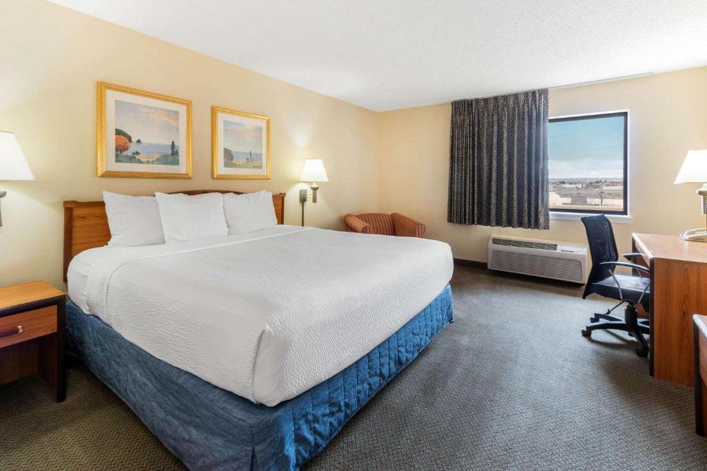 a hotel room with a large bed and a desk at La Quinta Inn & Suites by Wyndham Las Cruces Organ Mountain in Las Cruces