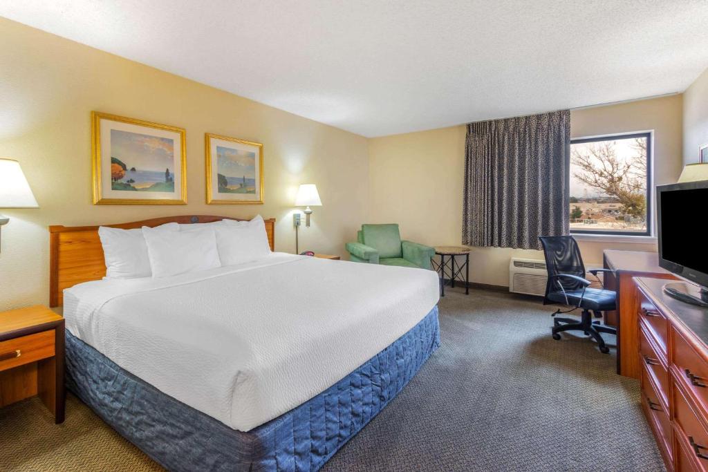 a hotel room with a bed and a desk and a television at La Quinta Inn & Suites by Wyndham Las Cruces Organ Mountain in Las Cruces