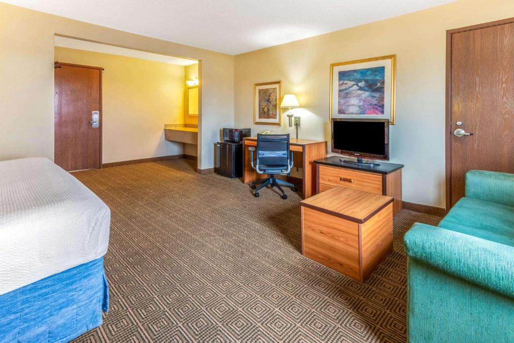 a hotel room with a bed and a desk with a television at La Quinta Inn & Suites by Wyndham Las Cruces Organ Mountain in Las Cruces