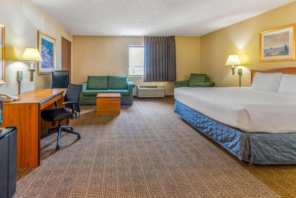 a hotel room with a bed and a desk and chairs at La Quinta Inn & Suites by Wyndham Las Cruces Organ Mountain in Las Cruces