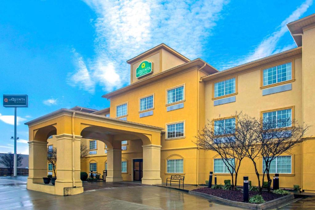 a large yellow building with a sign on it at La Quinta by Wyndham Fort Smith in Massard