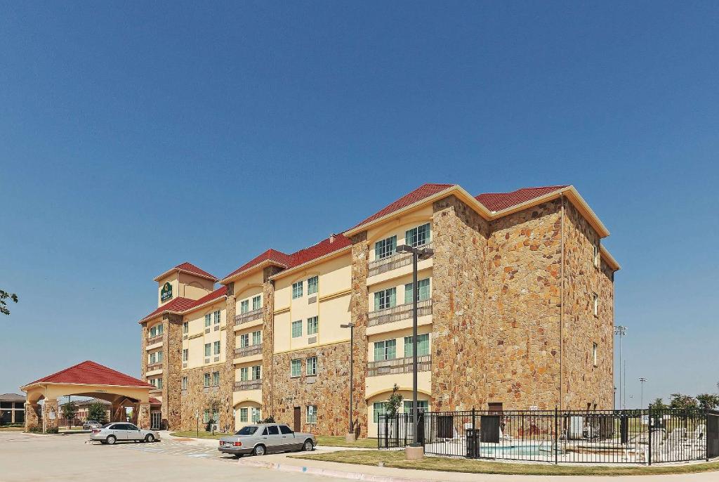 a large brick building with cars parked in front of it at La Quinta by Wyndham McKinney in McKinney