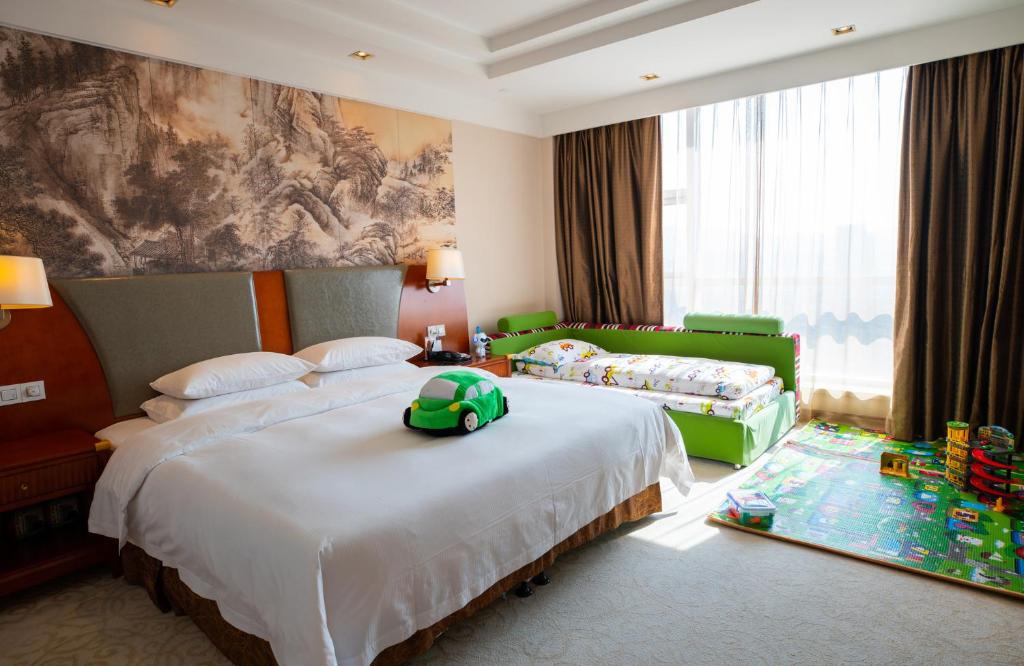 a bedroom with two beds with a toy turtle on the bed at Jinhai New Century Grand Hotel Ninghai in Ninghai