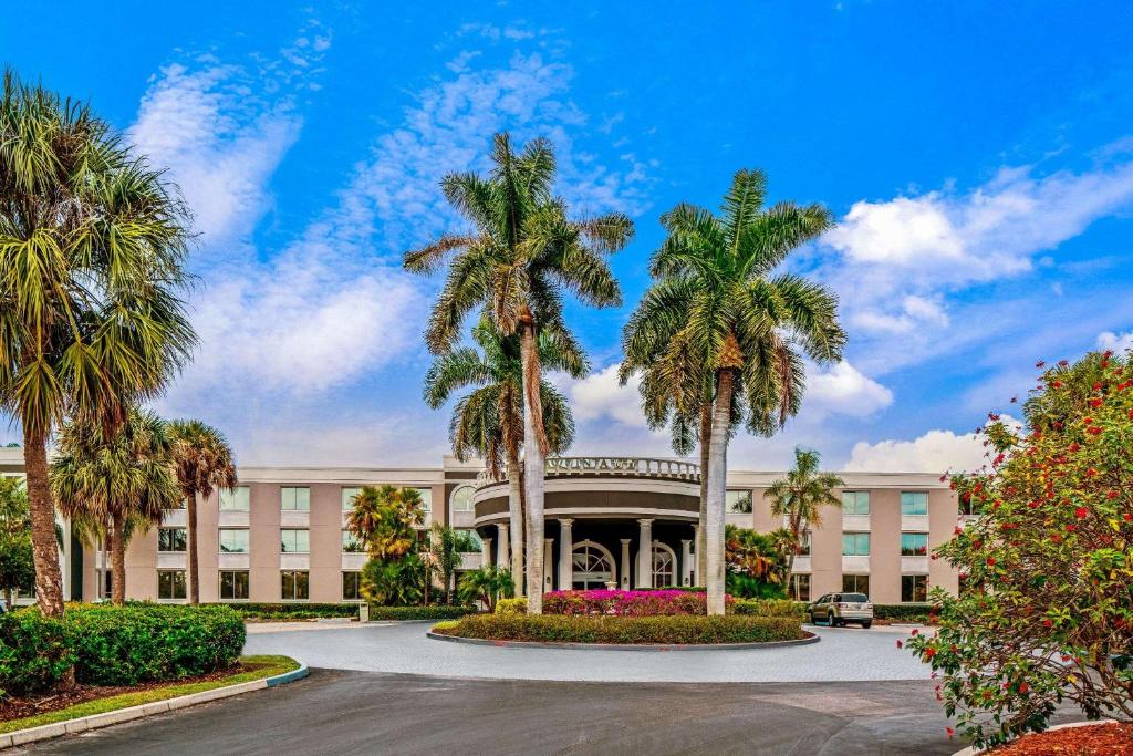 a building with palm trees in front of it at La Quinta by Wyndham Naples Downtown in Naples