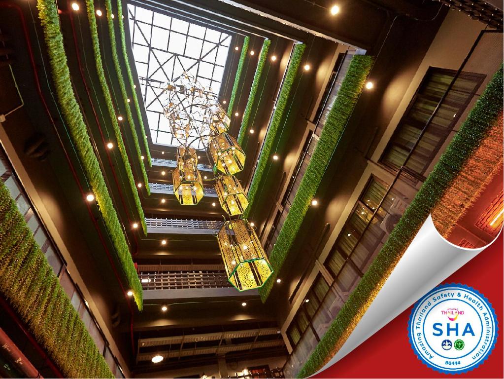 曼谷的住宿－布拉纱里W22酒店【SHA Plus+】，建筑中带吊灯的天花板