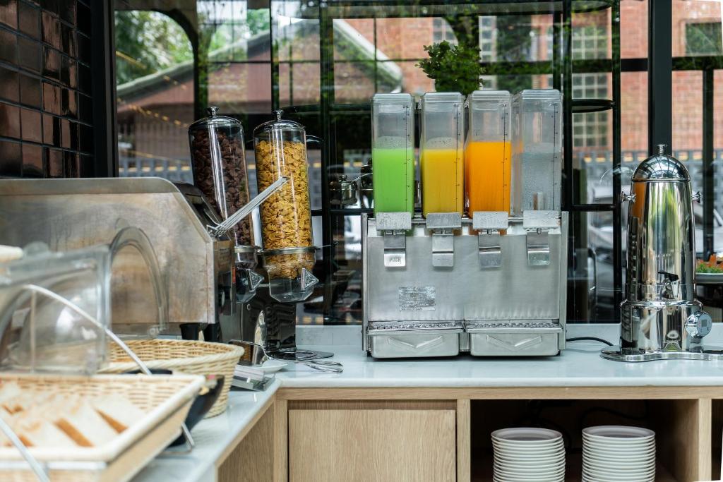 a counter with a bunch of drinks in glass containers at Hotel Amber Sukhumvit 85 in Bangkok