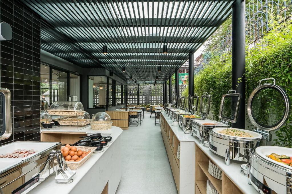 a restaurant with a long line of counters with food at Hotel Amber Sukhumvit 85 in Bangkok