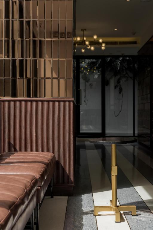 a room with a bench and a table in it at Hotel Amber Sukhumvit 85 in Bangkok