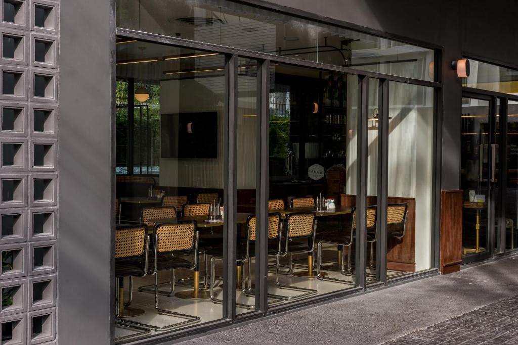 a dining room with glass windows and tables and chairs at Hotel Amber Sukhumvit 85 in Bangkok