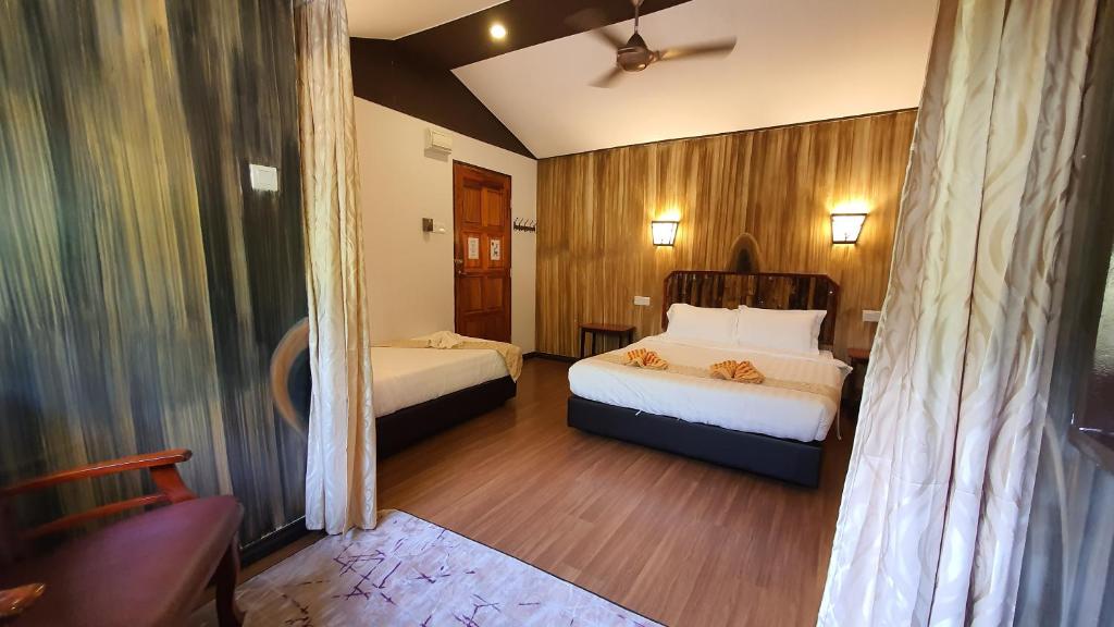 Habitación de hotel con 2 camas y sofá en Bilit Adventure Lodge en Bilit