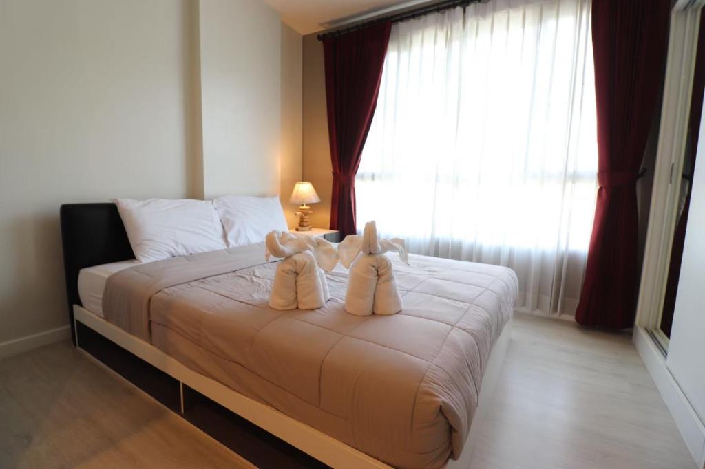 a bedroom with two teddy bears sitting on a bed at D Condo Sign Chiang Mai R628 in Chiang Mai