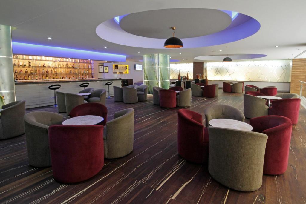 um lobby com um monte de cadeiras e um bar em Presidente InterContinental Guadalajara, an IHG Hotel em Guadalajara
