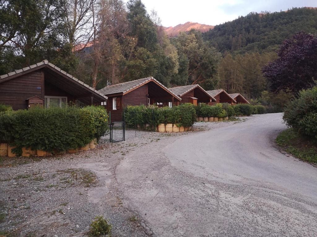 a dirt road next to a row of wooden cabins at Chalet calme in Saint-Léger-les-Mélèzes
