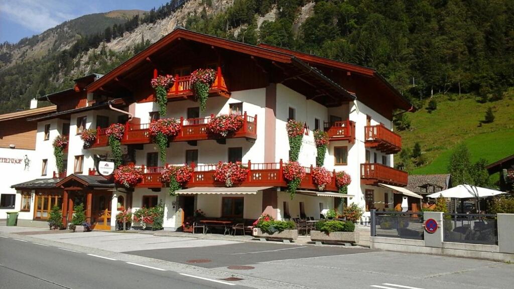 ein Gebäude mit roten Balkonen und Blumen darauf in der Unterkunft Hotel UNTERKRÄMERHOF in Fusch an der Glocknerstraße