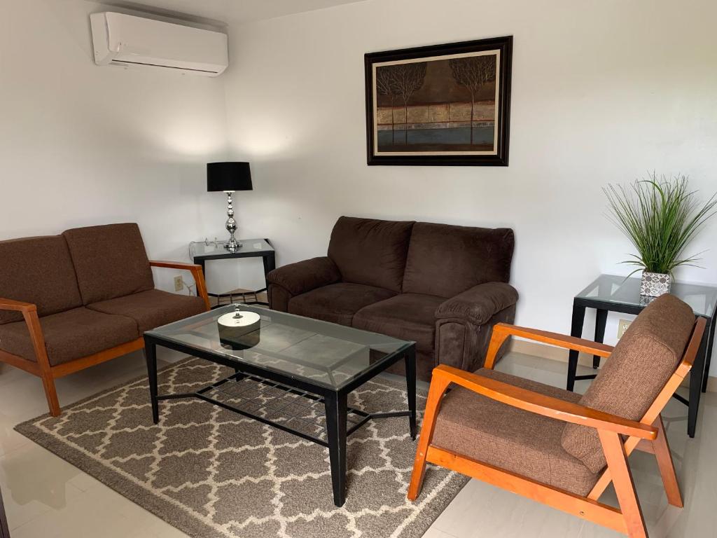 sala de estar con sofá, mesa y sillas en Private Chalan Pago Apartment en Hagatna