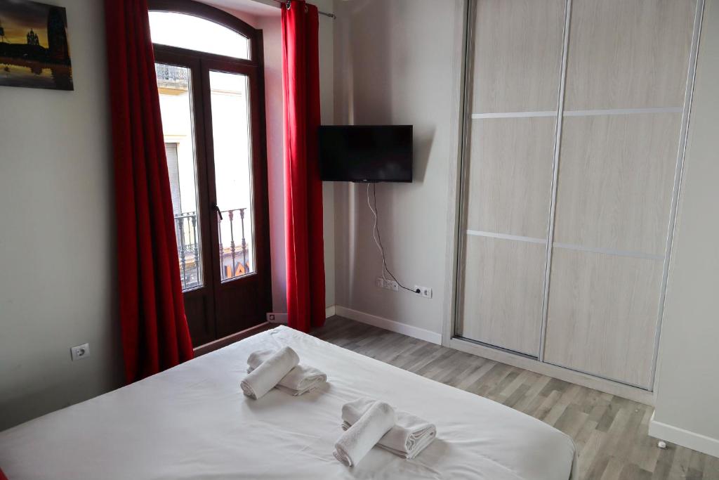 1 dormitorio con 1 cama con 2 toallas en Triana Suite Dreams, en Sevilla