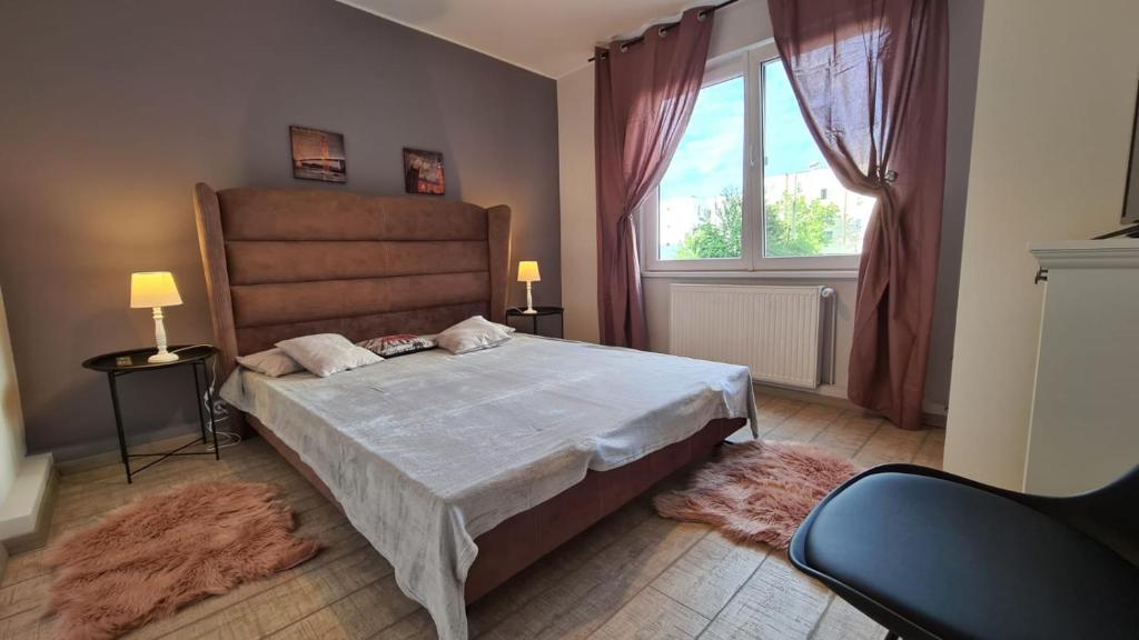 a bedroom with a large bed and a large window at Maris Apartment in Târgu-Mureş
