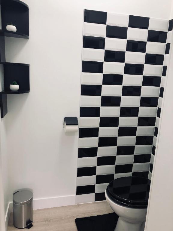 a bathroom with a black and white checkered shower curtain at Gîte avec jardin à 1,5 km des plages du débarquement in Tracy-sur-Mer