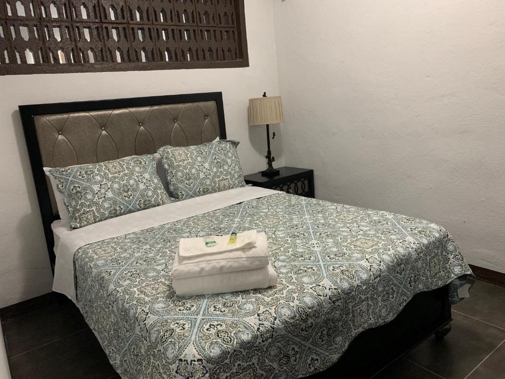 ein Schlafzimmer mit einem Bett und einer Handtasche darauf in der Unterkunft BEAUTIFUL 3 BEDROOM PRIVATE UNIT, FREE PARKING, FREE WIFI in Sinajana