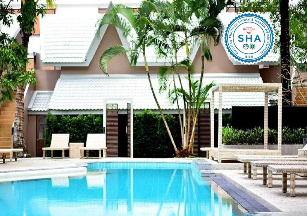 uma piscina em frente a um edifício com uma placa de hotel em Deevana Krabi Resort - SHA Extra Plus em Praia de Aonang