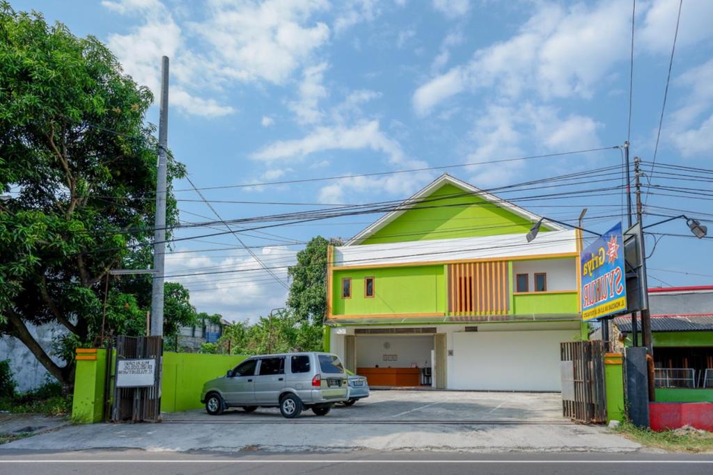 een auto geparkeerd op een parkeerplaats voor een gebouw bij RedDoorz @ Jalan Wonosari KM.9 in Yogyakarta