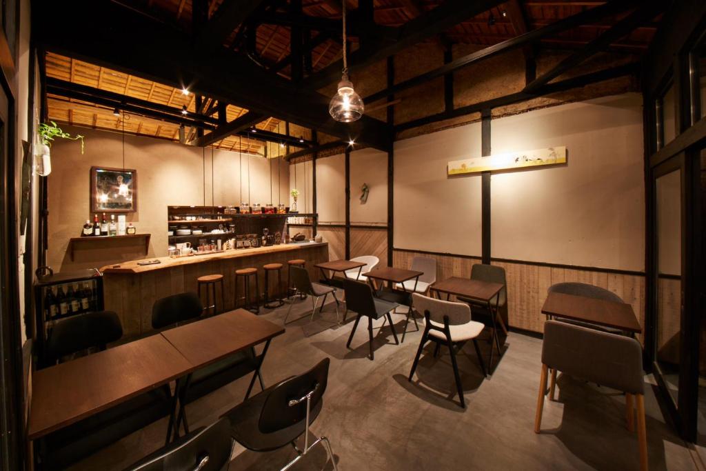 um restaurante com mesas e cadeiras e um bar em sakainoma hotel 熊 em Sakai