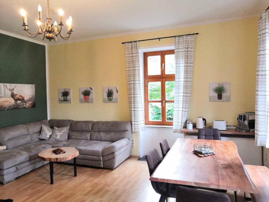 a living room with a couch and a table at Ferienappartment zum grünen Hirsch in Bad Ischl