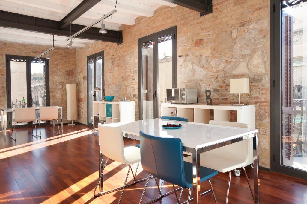 a dining room with a brick wall and a table and chairs at AB Paral·lel Apartments in Barcelona
