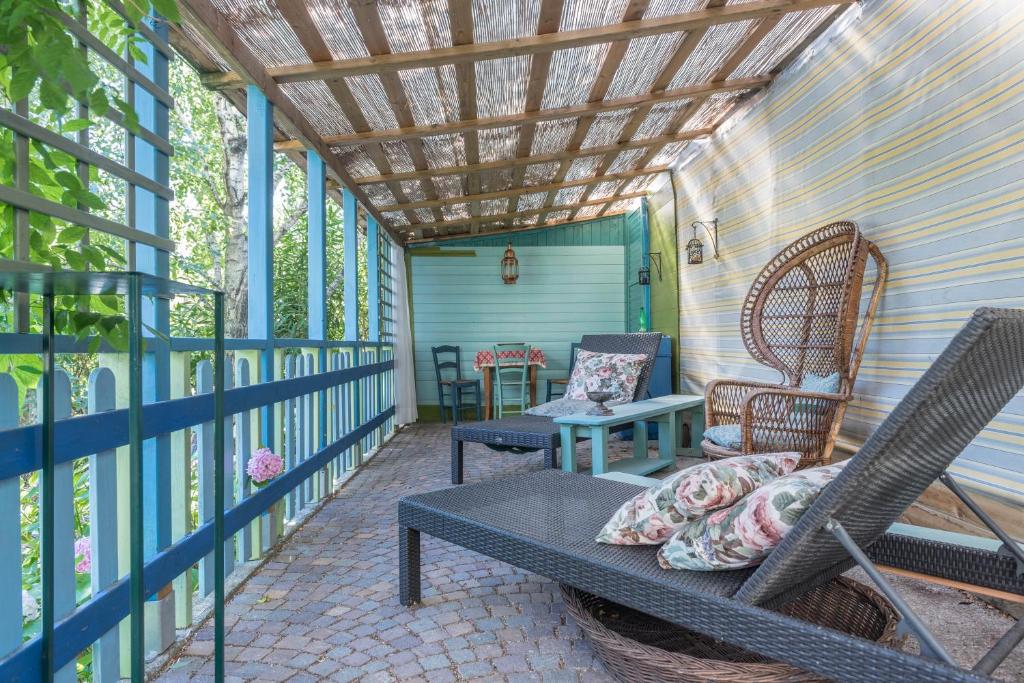 eine Veranda mit Stühlen, einem Sofa und einem Tisch in der Unterkunft Casa Jasmina in Dro