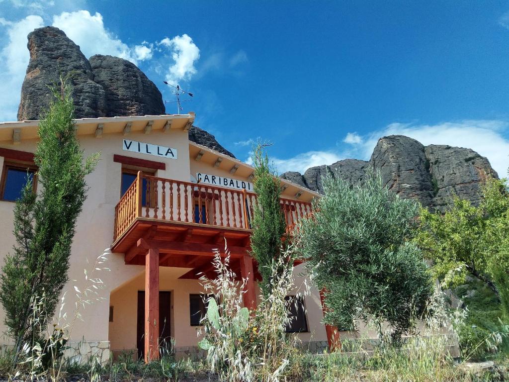 a building with a balcony in front of a mountain at villa Garibaldi in Agüero