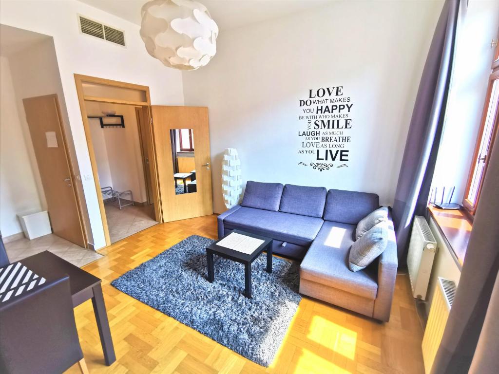 a living room with a blue couch and a table at Gozsdu Apartment in Budapest